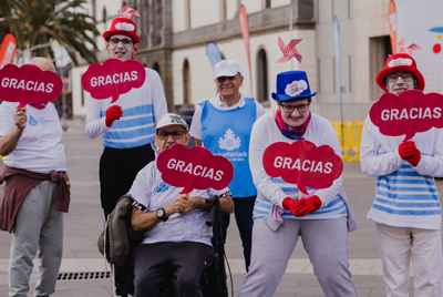 Hombre y mujeres con cartel de gracias