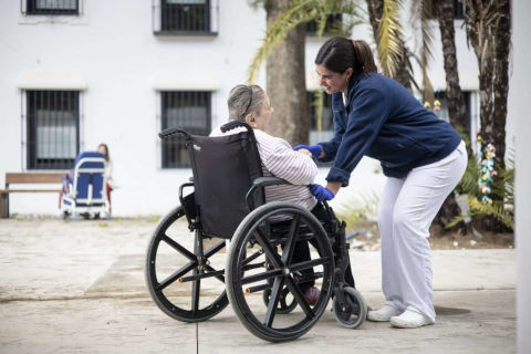Cuidadora con anciana en silla de ruedas
